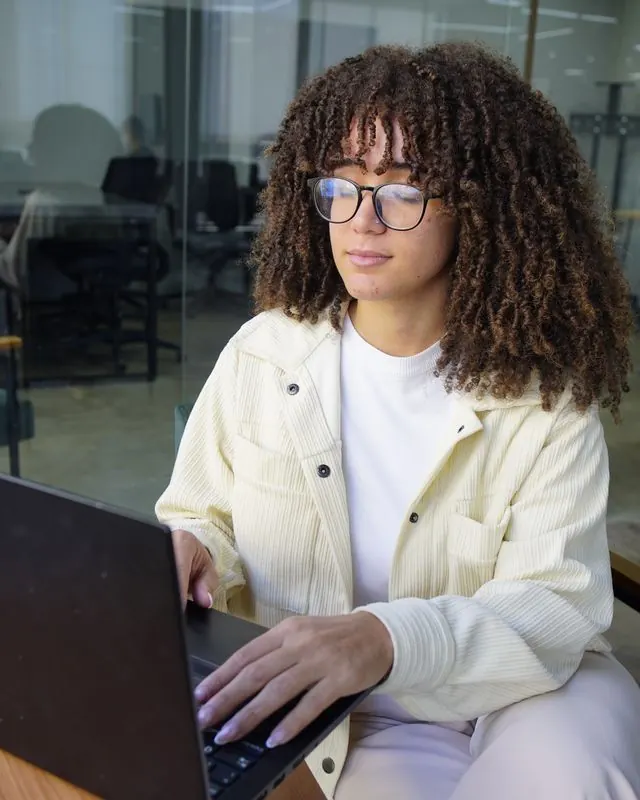 Pessoa da equipe trabalhando no notebook, no escritório da MPC